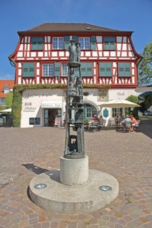 Snowball column by Gerold Jäggle with sculpture, figures by Hansjakob, column, half-timbered house