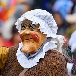 Person masked as a grandmother at the carnival parade of the Wey guild on Rose Monday, Güdismäntig,