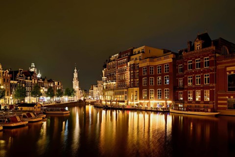 Historic buildings and mint tower illuminated at night, Singelgracht, Amsterdam, North Holland,