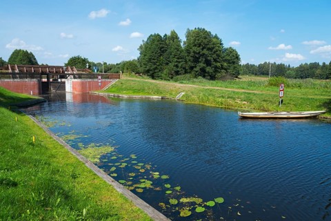 A lock is located on a river with water lilies, surrounded by green nature, Tartak Lock, Augustow
