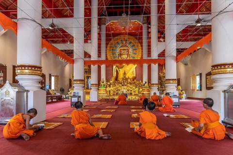 Monks and novices praying in the Buddhist temple Wat Phra Singh, Chiang Mai, Thailand, Asia