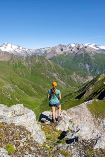 Mountaineer sitting on a rock in front of a mountain panorama with Großvenediger, mountain