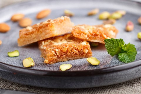 Traditional arabic sweets in gray ceramic plate on a gray concrete background. side view, close up,
