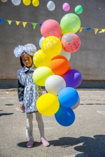 Happy schoolgirl with colourful balloons on the first day of school, Issyk-Kul region, Kyrgyzstan,