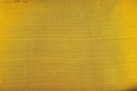 Fragment of smooth yellow and green tissue. Top view, flat lay, synthetic textile background and
