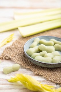 Jelly celery candies on white wooden background and linen textile. close up, side view, selective