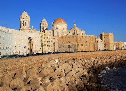 Coastal view east of rock armour coastal defences and cathedral, Cadiz, Spain, Europe