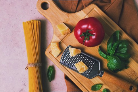 Raw pasta with ingredients on a beige background, top view, rustic style, selective focus, no