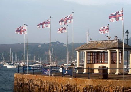 RNLI flags flying in the breeze on Prince of Wales pier, Falmouth, Cornwall, England, UK