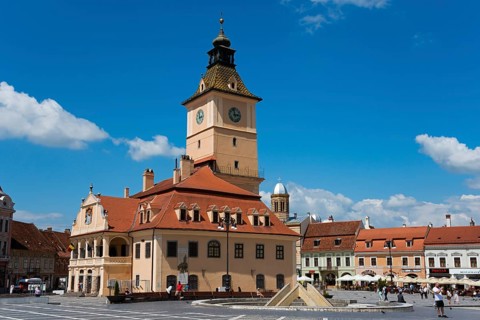 Market square on a sunny day with historic building with tower clock and relaxed people, Old town