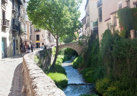 Historic buildings on Carrera del Darro and old bridge over the Rio Darro river, Granada, Spain,