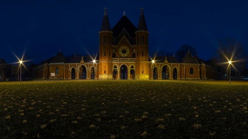 Main entrance of the cemetery in Hanover Stöcken with a lawn with crocuses in the foreground, dutch