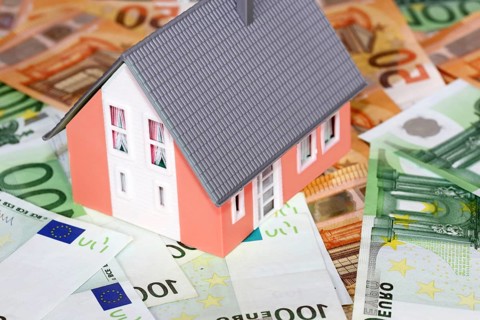 Concept photo with model house, euro notes and coins