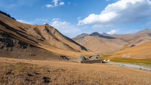 Historic caravanserai Tash Rabat from the 15th century, in the evening light with golden hills,