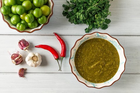 Tkemali sauce, traditional Georgian cuisine, green cherry plum, with ingredients for sauce,