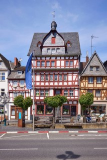 Multi-storey half-timbered house and European flag on the main street in Adenau, Eifel, Ahrweiler