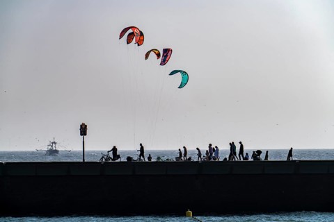 Kitesurfer off the coast of Scheveningen, walkers on the harbour pier, The Hague, Netherlands