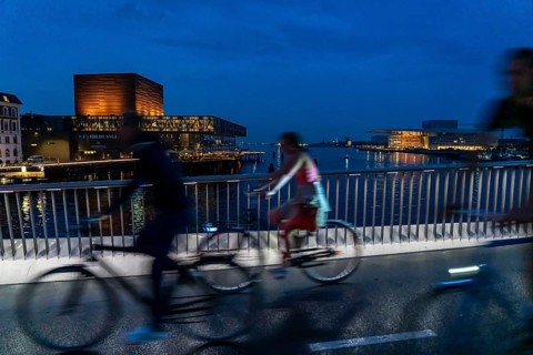 Cyclists on the Inderhavnsbroen cycle and footpath bridge, across the harbour, at night, at Nyhavn,