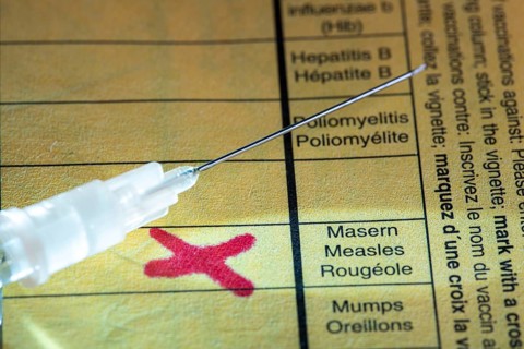Symbolic photo measles vaccination, vaccination certificate, syringe with measles vaccine
