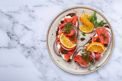 Sandwich with freshly smoked salmon, on black bread, with cottage cheese, with herbs and red