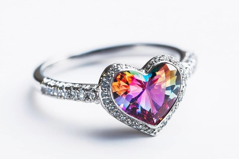 Silver Valentine's day ring with colorful heart shaped gem stone on white background. Generative