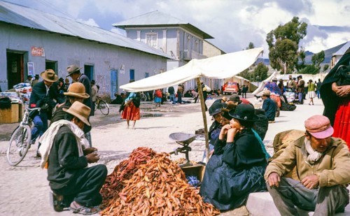 Subtitle: Border town Peru possibly Puno, Peru, South America, 1962 Street market with a pile of