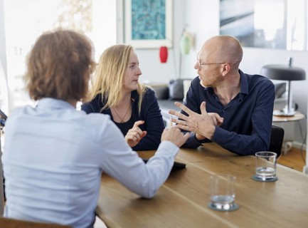 Symbolic photo on the subject of counselling. A young woman and a young man sit together at a table