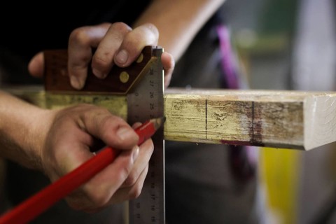A man tears a section on a piece of wood. Berlin, 14.08.2024
