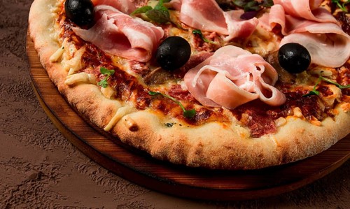 Pizza with prosciutto and mushrooms, bacon, olives, homemade, top view, no people