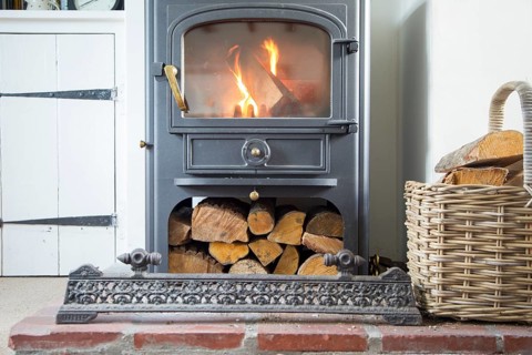 Warm fire flames logs burning in ClearView domestic multifuel stove burner inside home, UK