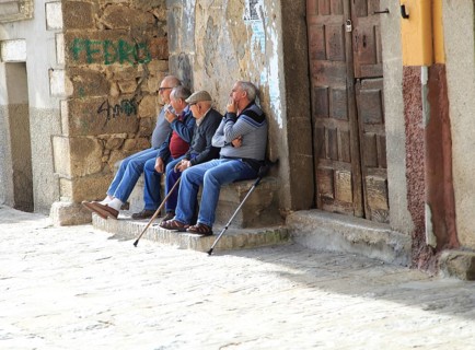 Men sitting together on stone bench, Garganta la Olla, La Vera, Extremadura, Spain, Europe