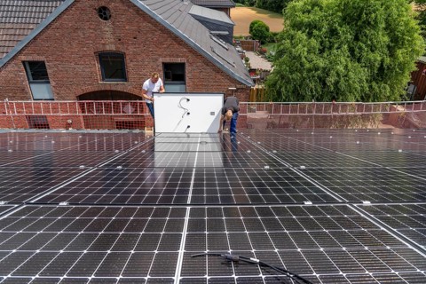 Installation of solar modules on the roof of a barn on a farm, over 210 photovoltaic modules are