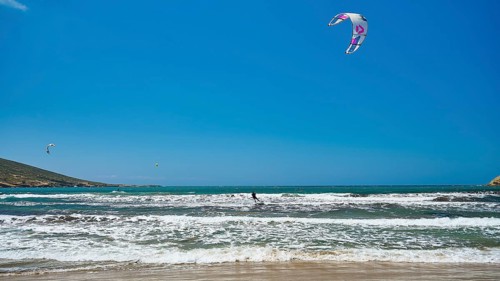 Kitesurfer on wavy sea under blue sky with kite, surfer's paradise, kitesurfer, windsurfer,