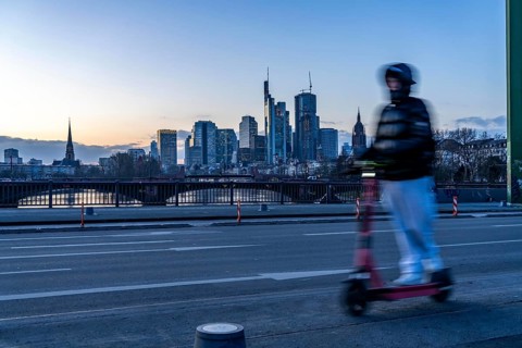 Skyline of the city centre of Frankfurt am Main, e-scooter on the raft bridge, dusk, river Main,