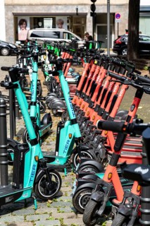 Electric scooters, e-scooters are parked in large numbers on the Burgmauer road, in front of