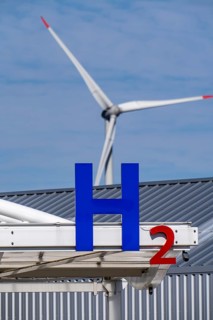 Hydrogen filling station in Antwerp, for cars and lorries, H2 lettering, wind turbine in the