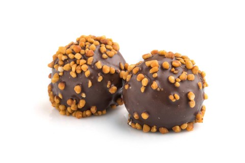 Chocolate caramel ball candies with almonds isolated on white background. Side view, close up