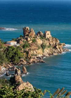 Ruins of Torre Caldura Castle on a rocky promontory jutting into the sea near Cefalu, Sicily,