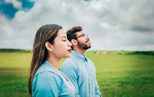 Young couple breathing fresh air in the field. Two relaxed people breathing fresh air in the field