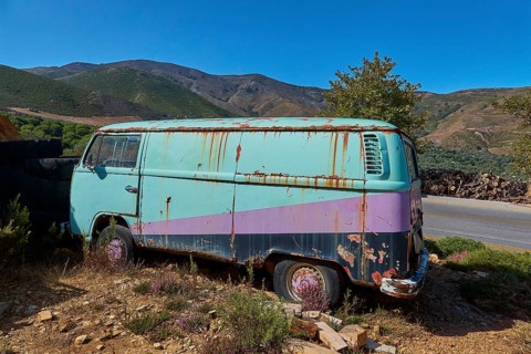 Rusty old van in hilly landscape under a bright blue sky, wrecked vehicle, Crete, Greek Islands,
