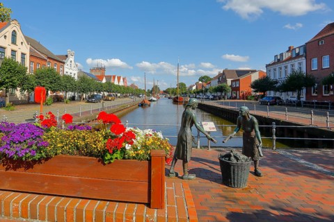 Old harbour with the bronze sculpture 'Törfwieven' in Weener, East Frisia, Lower Saxony, Germany,