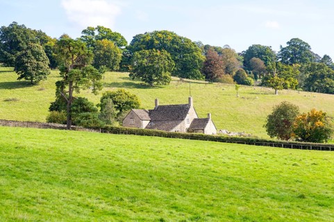 Cotswolds landscape of fields, trees, farmhouse building, near Yanworth, Gloucestershire, England,