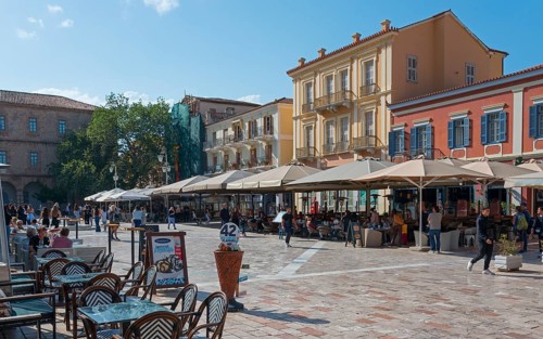 Busy square with cafés and parasols, surrounded by Mediterranean buildings, Syntagma Square,