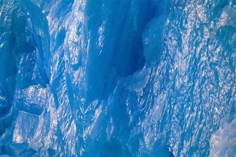 Ice wall in turquoise color with sun reflections on a glacier in arctic, Spitsbergen, Svalbard,