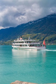 Large boat on a lake, forested mountains and clouds in the background, Lake Brienz, Switzerland,