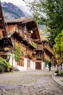 Person walking through a picturesque old street with half-timbered houses in autumn, Lake Brienz,