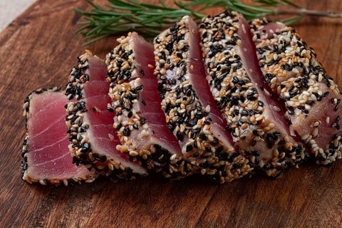 Fillet of red tuna meat, fried in sesame seeds, homemade, close-up, no people, on a wooden
