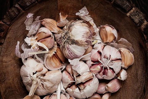 Fresh garlic, in a wooden plate, top view, close-up, no people