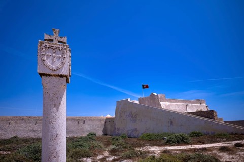 Memorial stone in honour of Henry the Navigator, Fortaleza de Sagres sea fortress, Portuguese flag,
