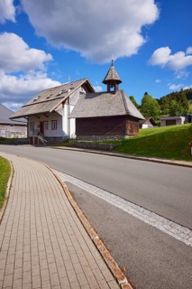 Chapel Unterlehen with road under blue sky with cumulus clouds in Bernau im Black Forest, Black